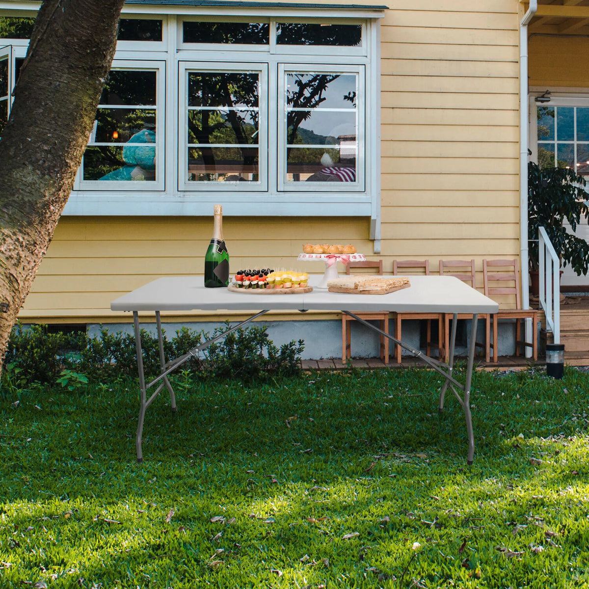 Witte klaptafel EASY UP MULTI II met afmetingen 152 x 70 cm op een grasveld voor een huis van hjh OFFICE