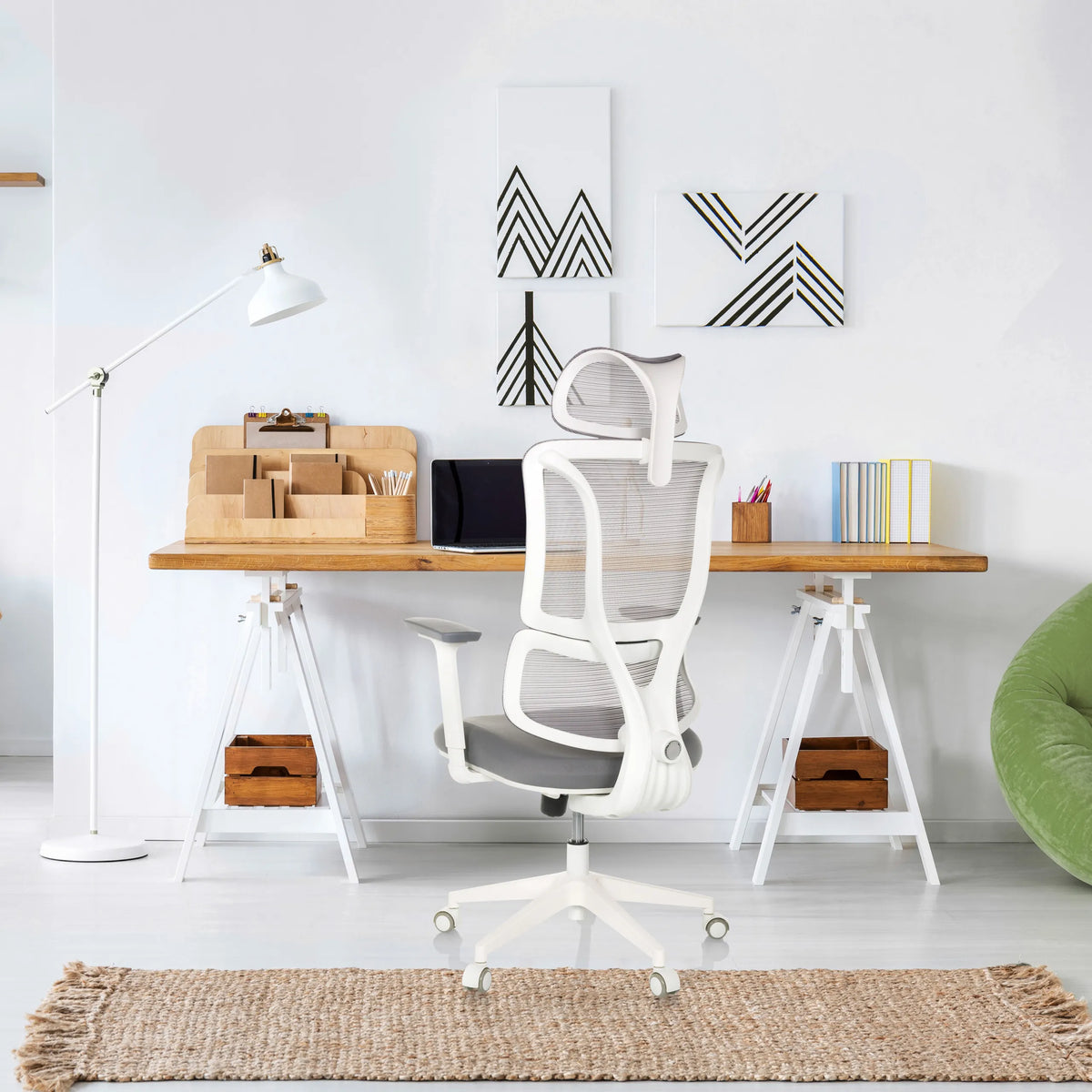 Professionele bureaustoel ERGOMY W in grijs met wit frame en netrugleuning aan een bureau van MyBuero