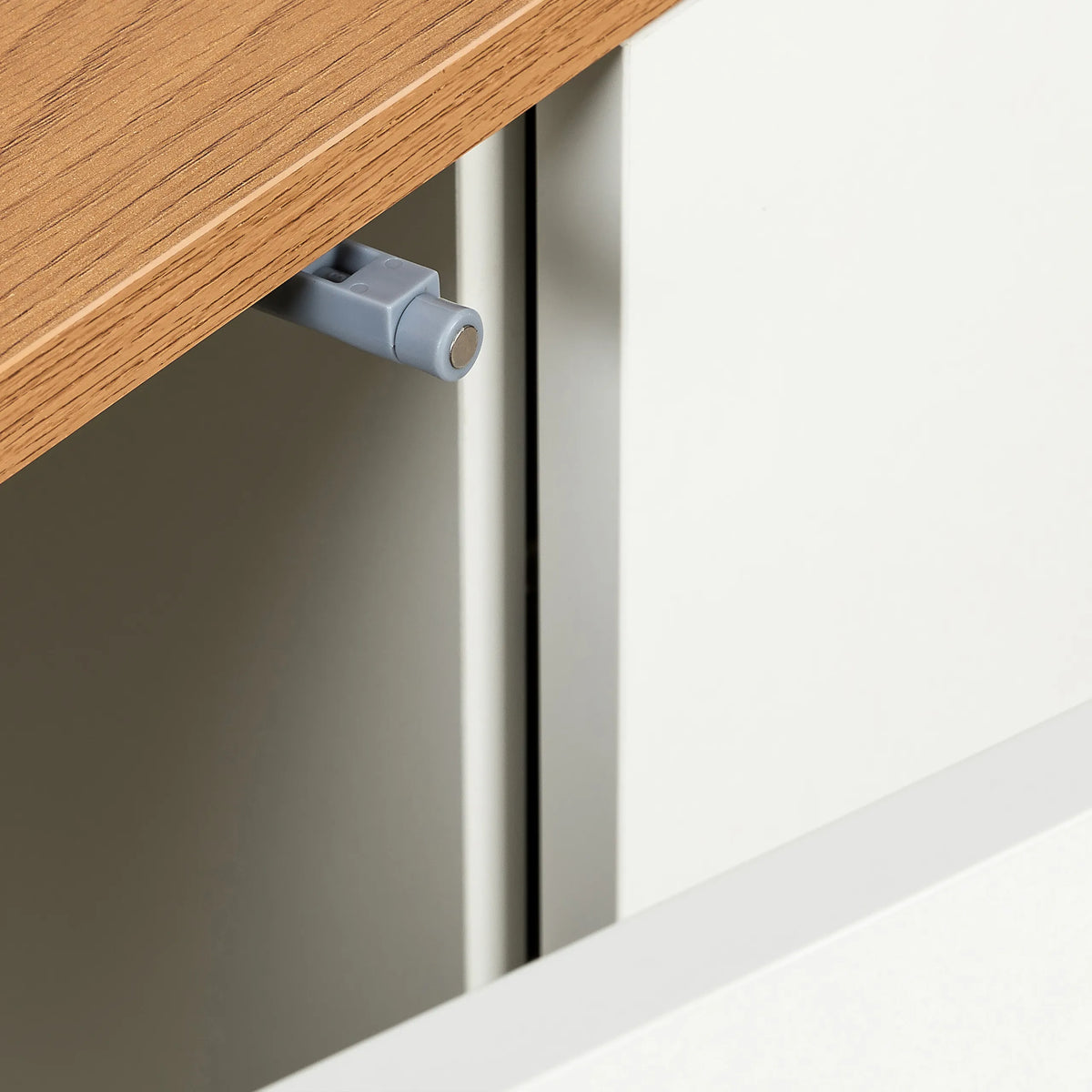Grijze deurstopper op het eikenkleurige blad van het Dressoir KELO S van hjh LIVING