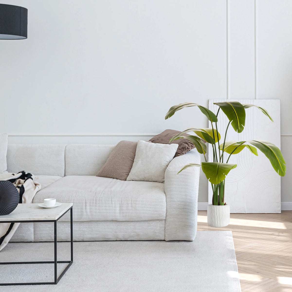 Groene Kunstplant BANANE in een witte pot naast een bank van hjh OFFICE