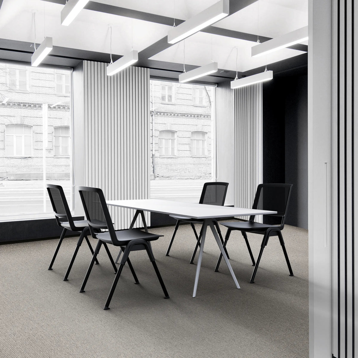 Vier zwarte MEET WA bezoekersstoelen aan een witte vergadertafel in een modern kantoor van hjh OFFICE