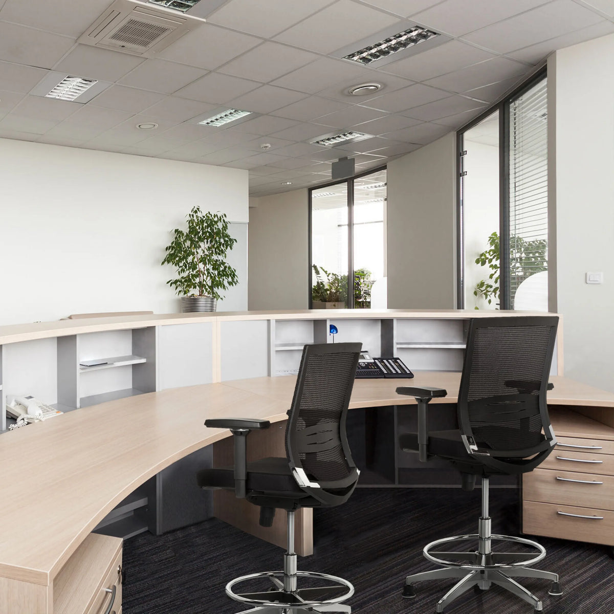 Twee zwarte TOP WORK 77 baliestoelen met netrugleuning en voetring aan een receptiebalie van hjh OFFICE