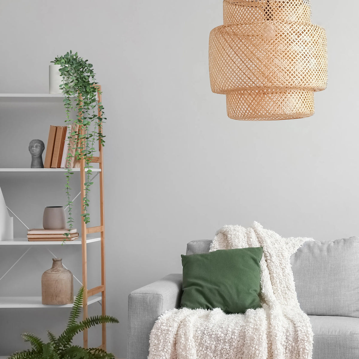 Groene Kunstplant EUCALYPTUS CLIMB in een kast naast een grijze bank van hjh OFFICE