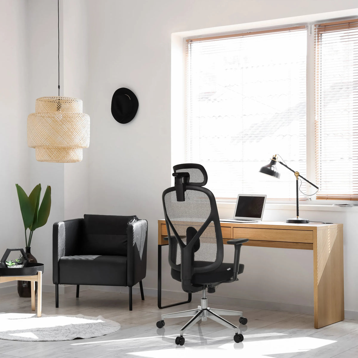 Professionele bureaustoel RALOO PRO in zwart met netrugleuning en hoofdsteun aan een bureau van hjh OFFICE