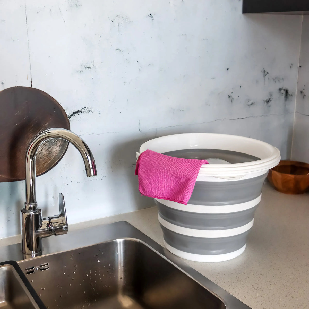 Grijs-witte Opvouwbare bak CLEAN SILR met een roze doek op een werkblad naast een gootsteen van hjh OFFICE