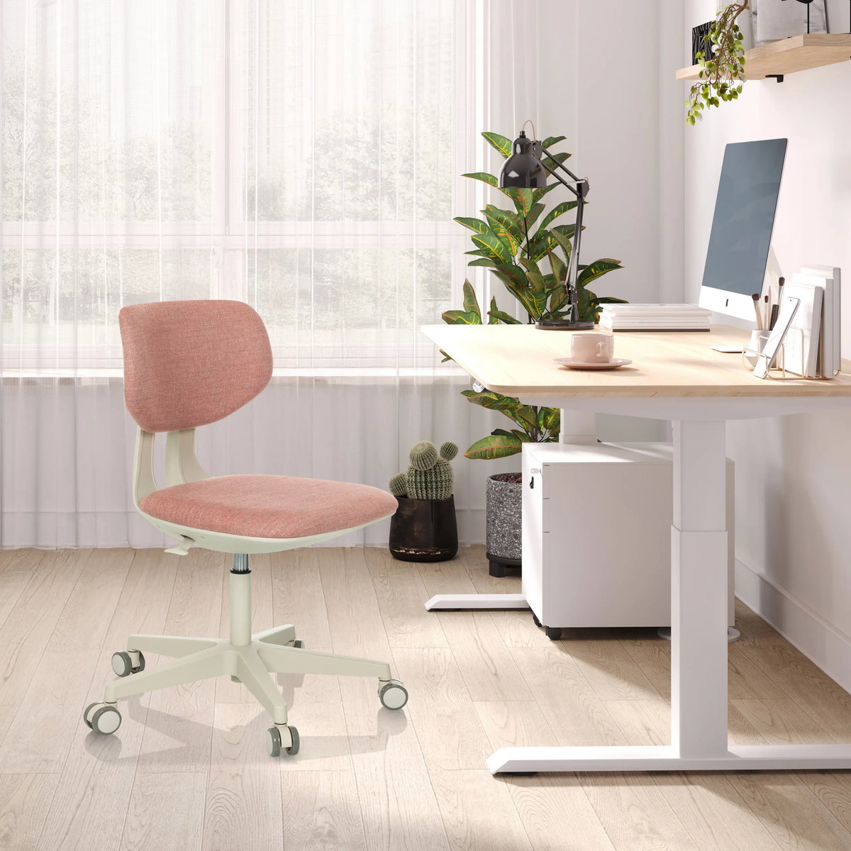 Roze kinder bureaustoel KID CLASSIC met wit frame en wieltjes aan een lichtgekleurd bureau van hjh OFFICE
