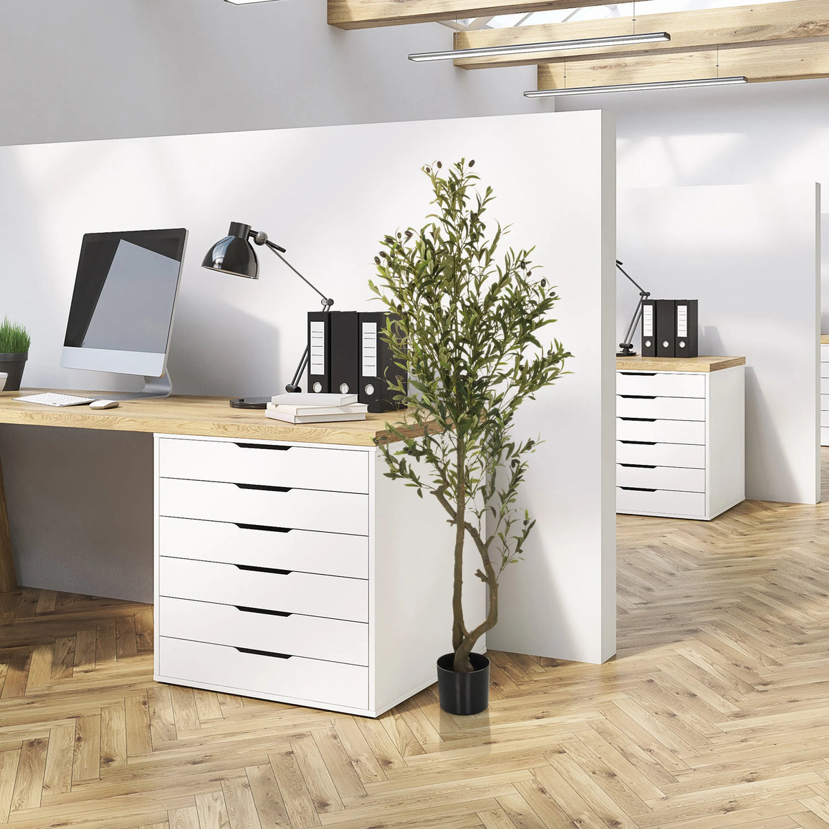 Groene Kunstplant OLIVE I in een zwarte pot naast een bureau van hjh OFFICE