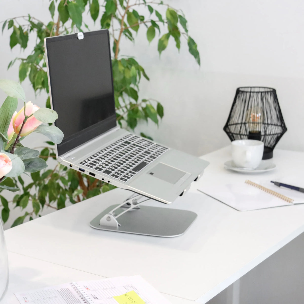 Zilveren onderzetter LAPTOP STAND met verstelbaar frame op een wit bureau van hjh OFFICE