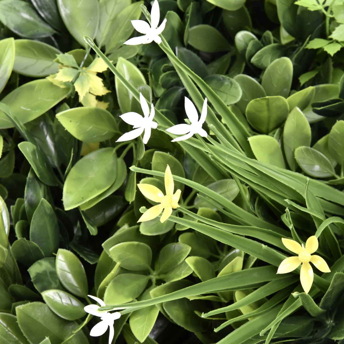 Groene bladeren met kleine witte en gele bloemen van de Plantmat LEAFLUXE WALL 2 van hjh LIVING