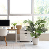 Groene kunstplant ARECA II in een witte overpot naast een witte rolcontainer van hjh OFFICE