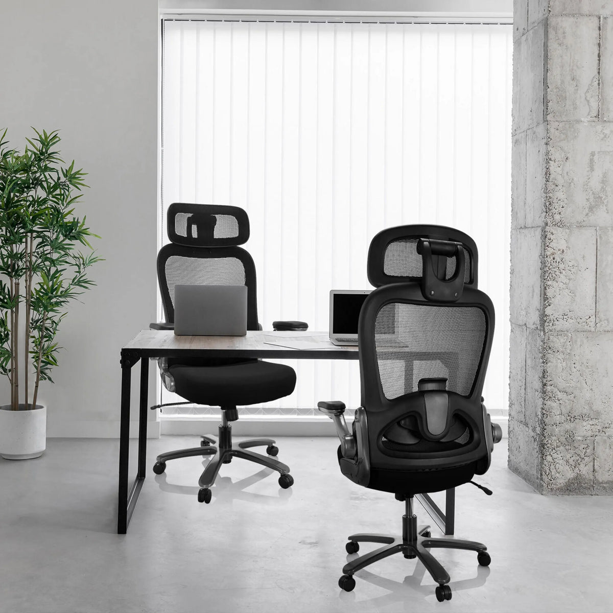 Twee XXL bureaustoelen INSTRUCTOR T I PRO met netrug en stoffen bekleding in zwart aan een bureau van hjh OFFICE