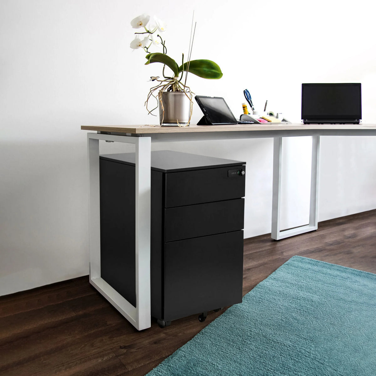 Zwart metalen ladeblok COLOR OS I onder een bureau met een licht houten blad van hjh OFFICE