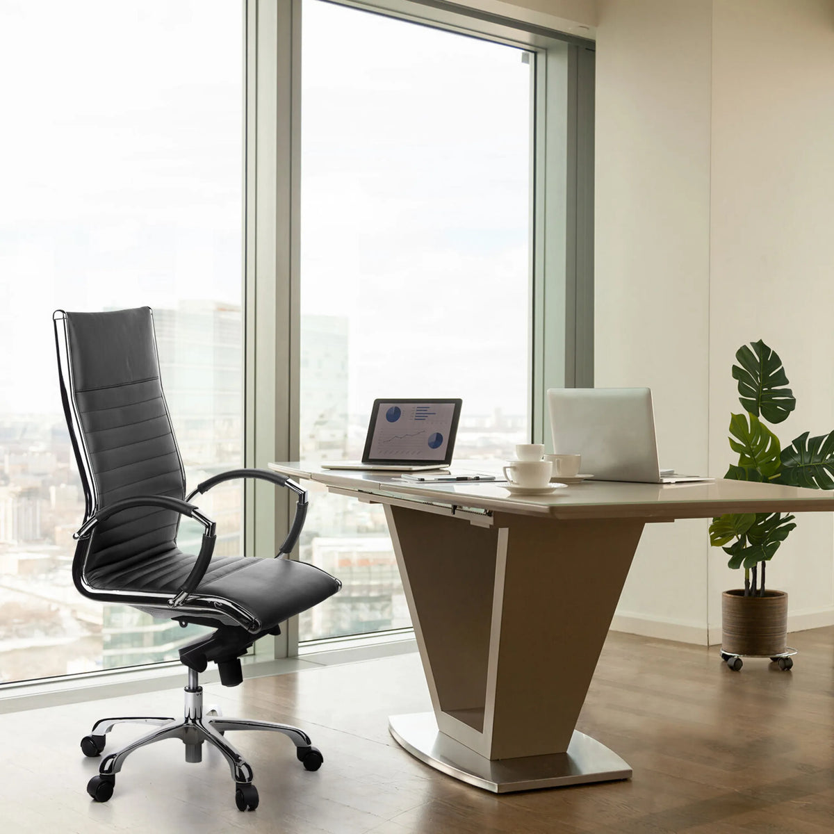 Professionele directiestoel PARMA 20 in zwart met gewatteerde bekleding en een verchroomd onderstel aan een bureau van hjh OFFICE
