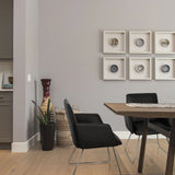 Zwarte gestoffeerde stoel DESIGNIA V met slanke metalen poten aan een houten tafel van hjh OFFICE