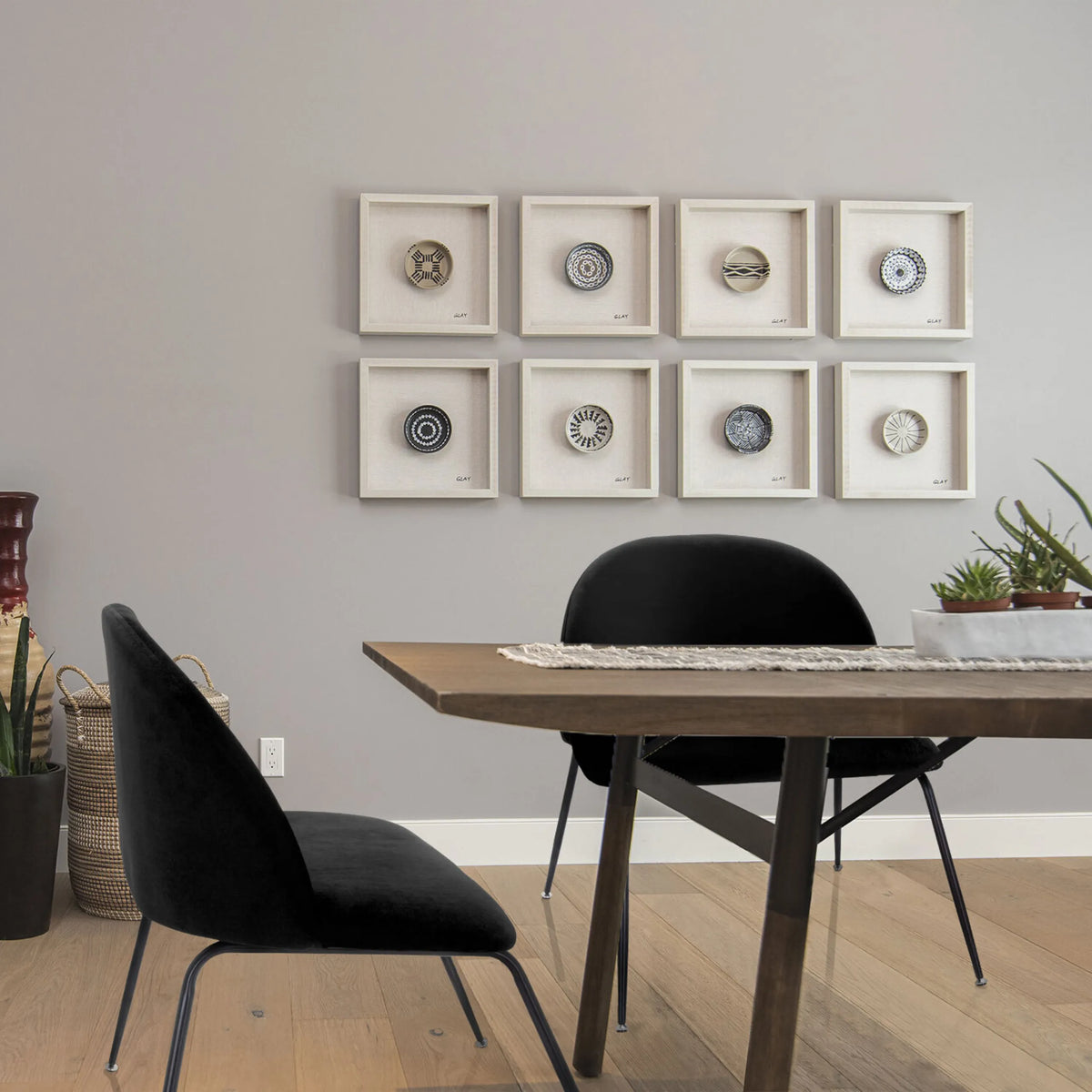 Zwarte gestoffeerde stoel VELVO met slanke metalen poten aan een eettafel van hjh OFFICE