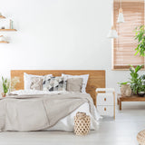 Witte bijzettafel TAROLO III met twee laden naast een bed van hjh LIVING