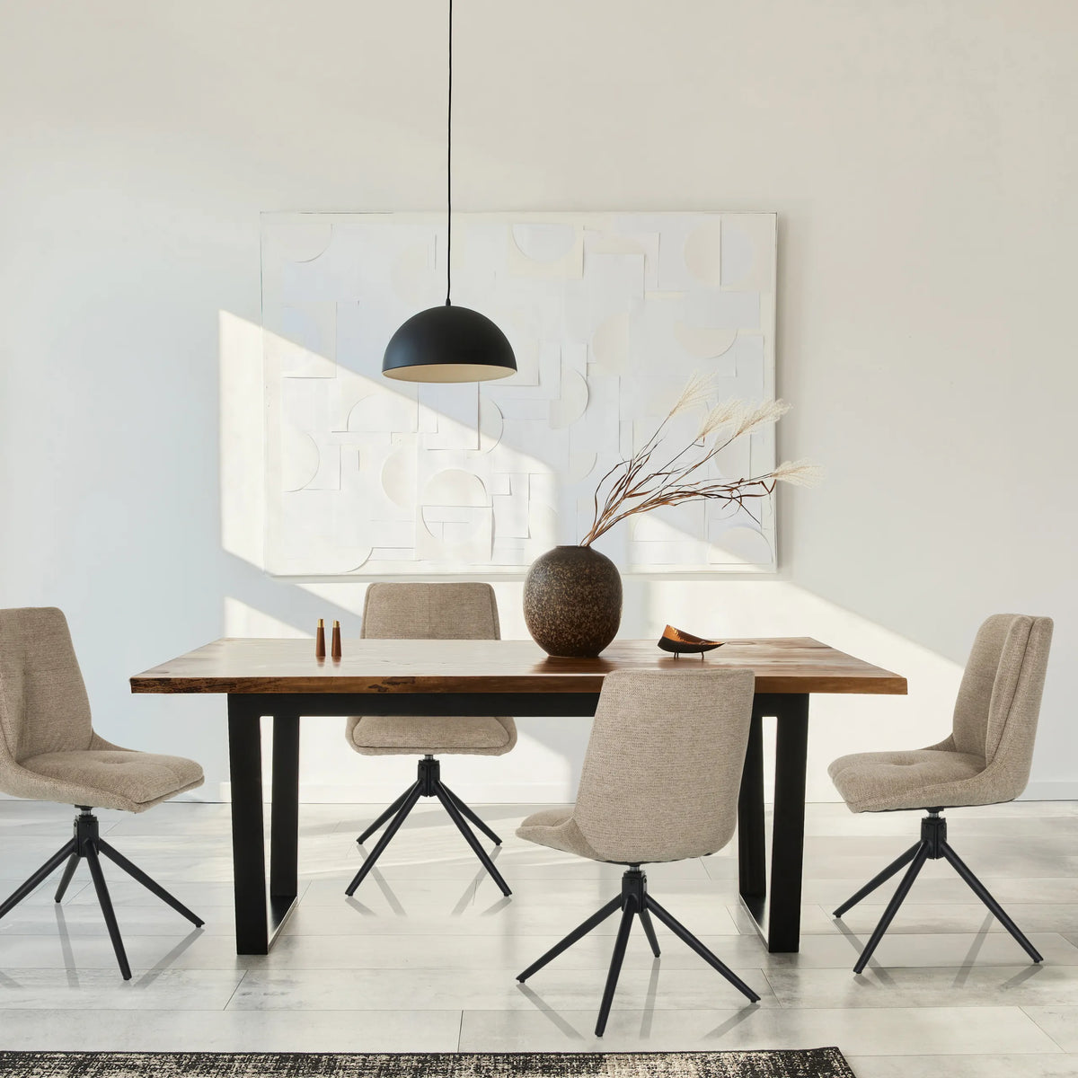Vier beige gestoffeerde stoelen TARVISO I met zwarte stervormige onderstellen aan een houten tafel van hjh LIVING