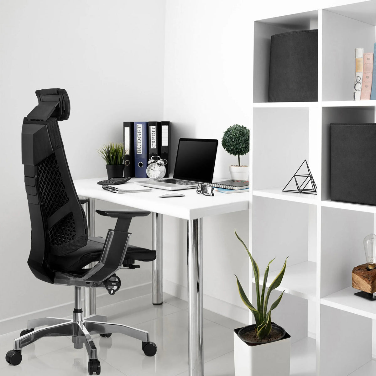Zwarte high end bureaustoel GENIDIA PRO van leer aan een wit bureau van hjh OFFICE