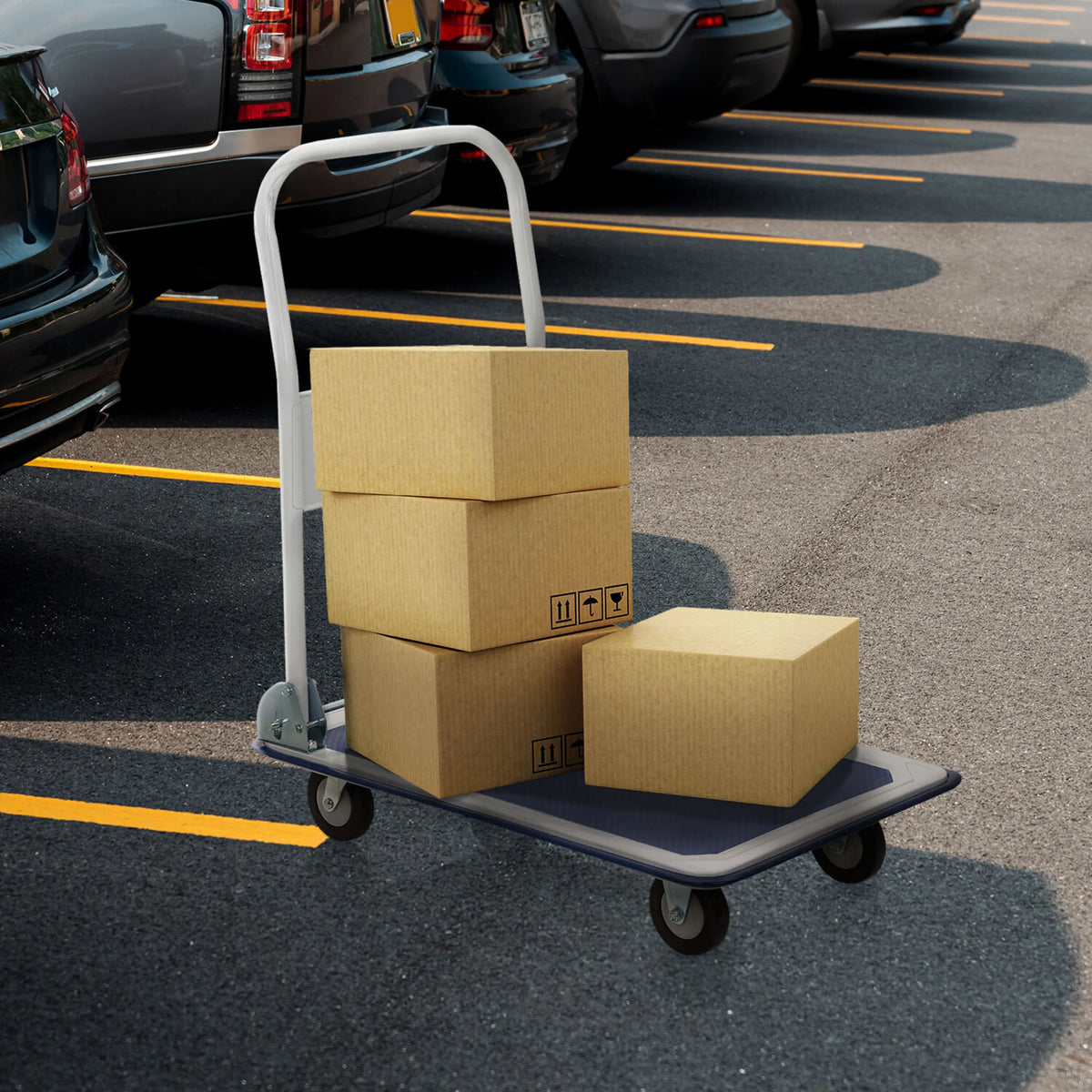 Blauw-witte platformwagen CARRY met drie geladen kartonnen dozen op een parkeerplaats van hjh OFFICE