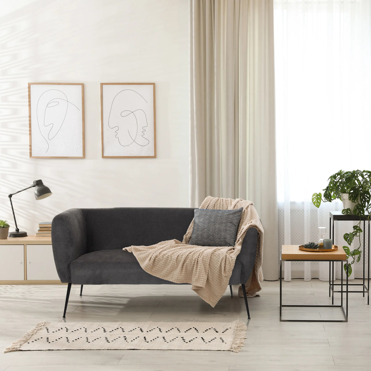 Grijze lounge bank HAYRIVER met kussens en een plaid in een lichte kamer van hjh LIVING