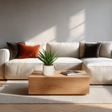 Kunstplant Agave in het groen met een witte pot op een houten tafel voor een lichte bank van hjh OFFICE