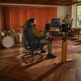 Kantoorstoel LiberNovo Maxis Airflow in grafiet aan een in hoogte verstelbaar bureau in een muziekstudio van Libernovo