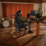 Kantoorstoel LiberNovo Maxis Elektric in grafiet in een muziekstudio met bureau en drumstel van Libernovo