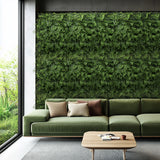 Groene plantmat LEAFLUXE 2 als verticale beplanting aan een muur achter een sofa van hjh LIVING