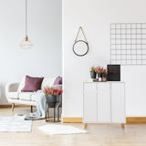 Witte commode ESTHA met twee deuren en lichte houten poten in een lichte woonkamer van hjh LIVING