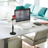Zwarte FLEXMOBI II houder voor mobiele telefoon & tablet op een wit bureau naast een monitor van hjh OFFICE