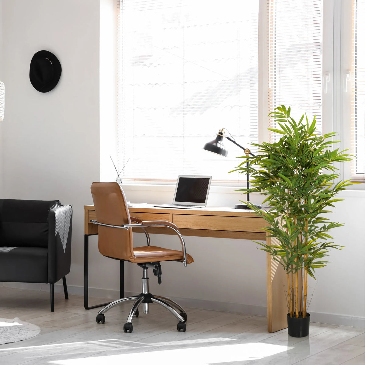 Groene Kunstplant BAMBUS II in een zwarte pot in een thuiskantoor van hjh OFFICE