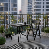 Zwarte klaptafel TRAVANO T1 met afmetingen 79 × 79 cm op een balkon van hjh LIVING (AI-gegenereerde afbeelding)