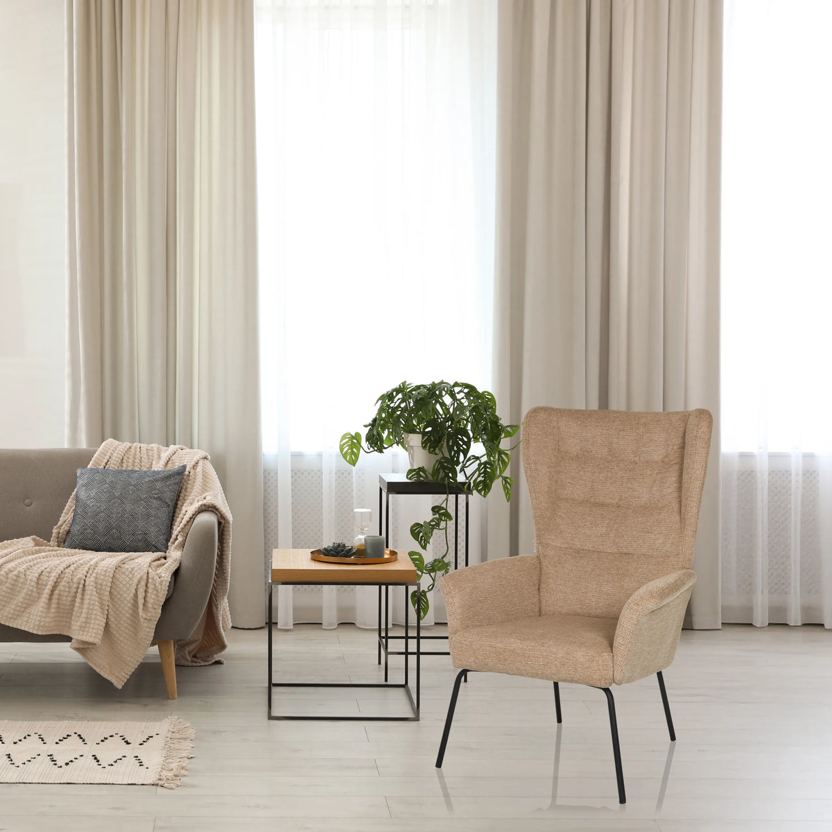 Beige gestoffeerde fauteuil HAVENIO met hoge rugleuning en zwarte metalen poten van hjh LIVING