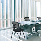 Klapstoel PRIORITY II in zwart met netbespannen rugleuning aan een conferentietafel van hjh OFFICE