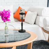Zwarte houder voor mobiele telefoon & tablet FLEXMOBI II met smartphone op een glazen tafel voor een witte bank van hjh OFFICE