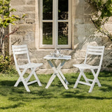 Twee witte Outdoor stoelen TRAVANO met bijpassende klaptafel op een grasveld van hjh LIVING